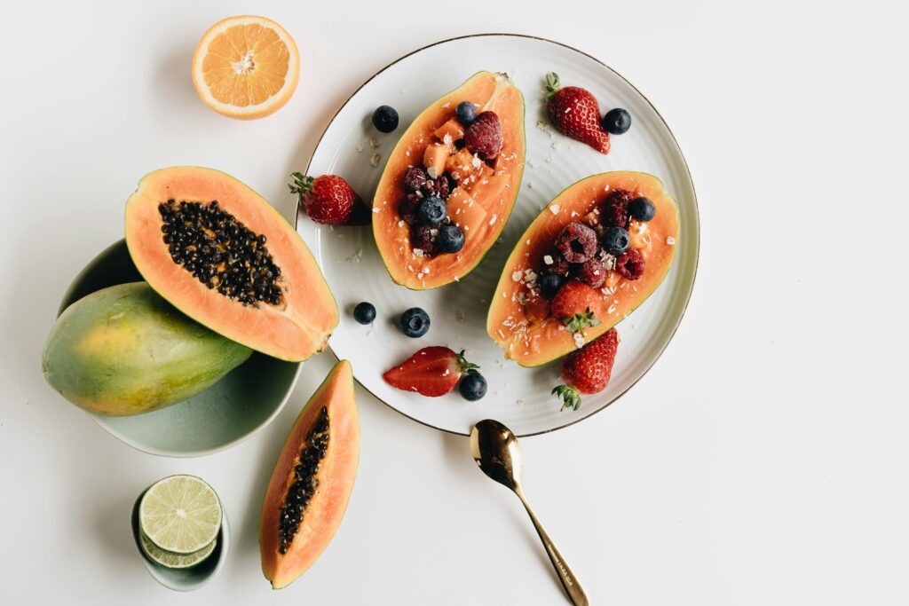 A vibrant plate of papaya filled with fresh berries and citrus slices for a nutritious meal.